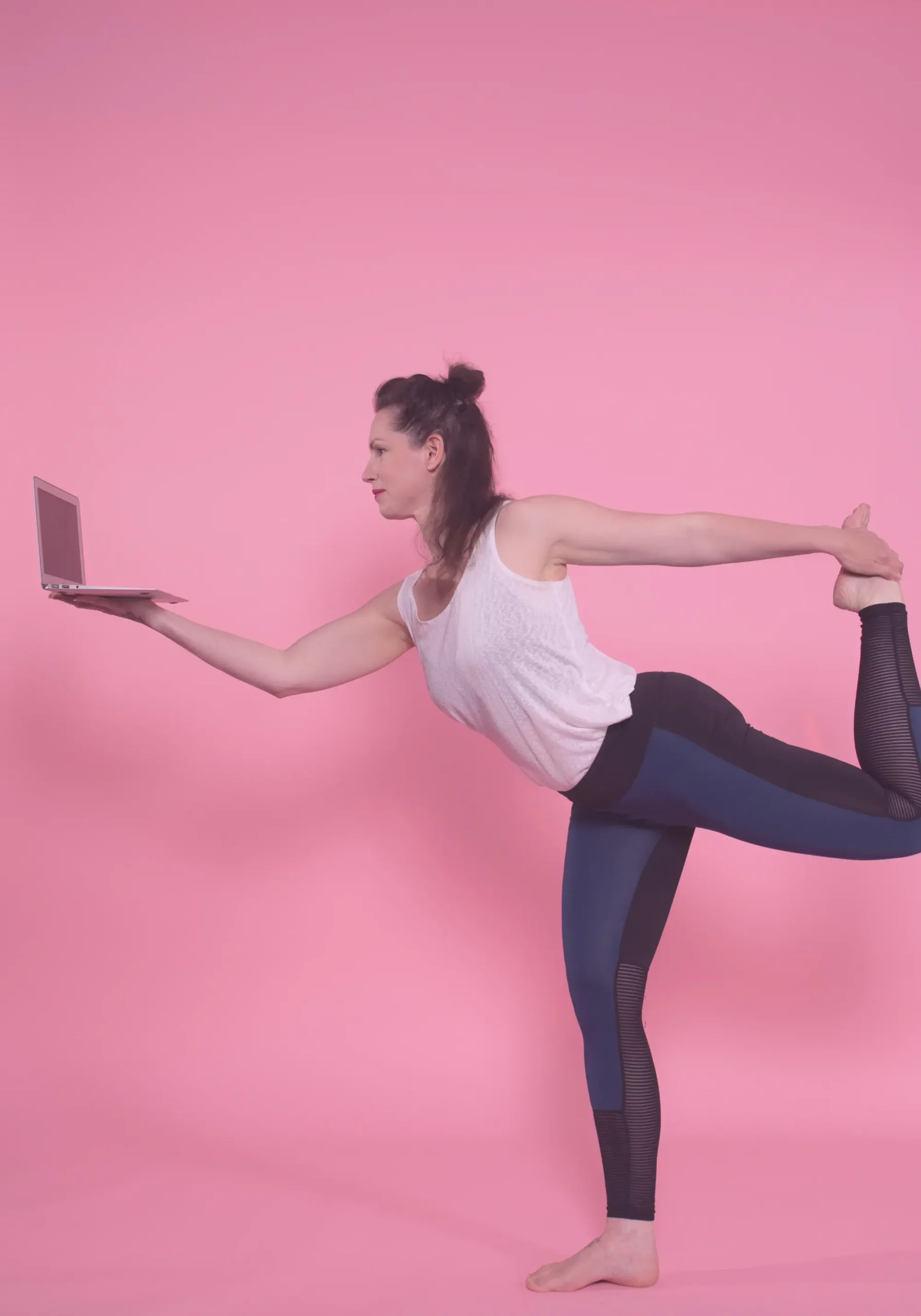 Woman practicing yoga with a laptop